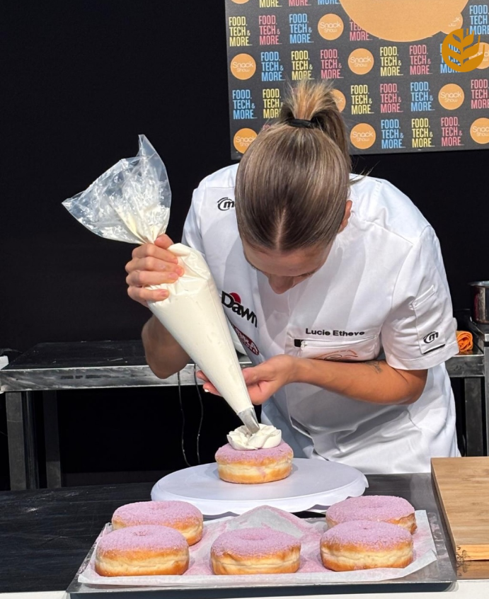 Lucie Etheve en train de garnir un donut à la main, artisanat The Donuts Island