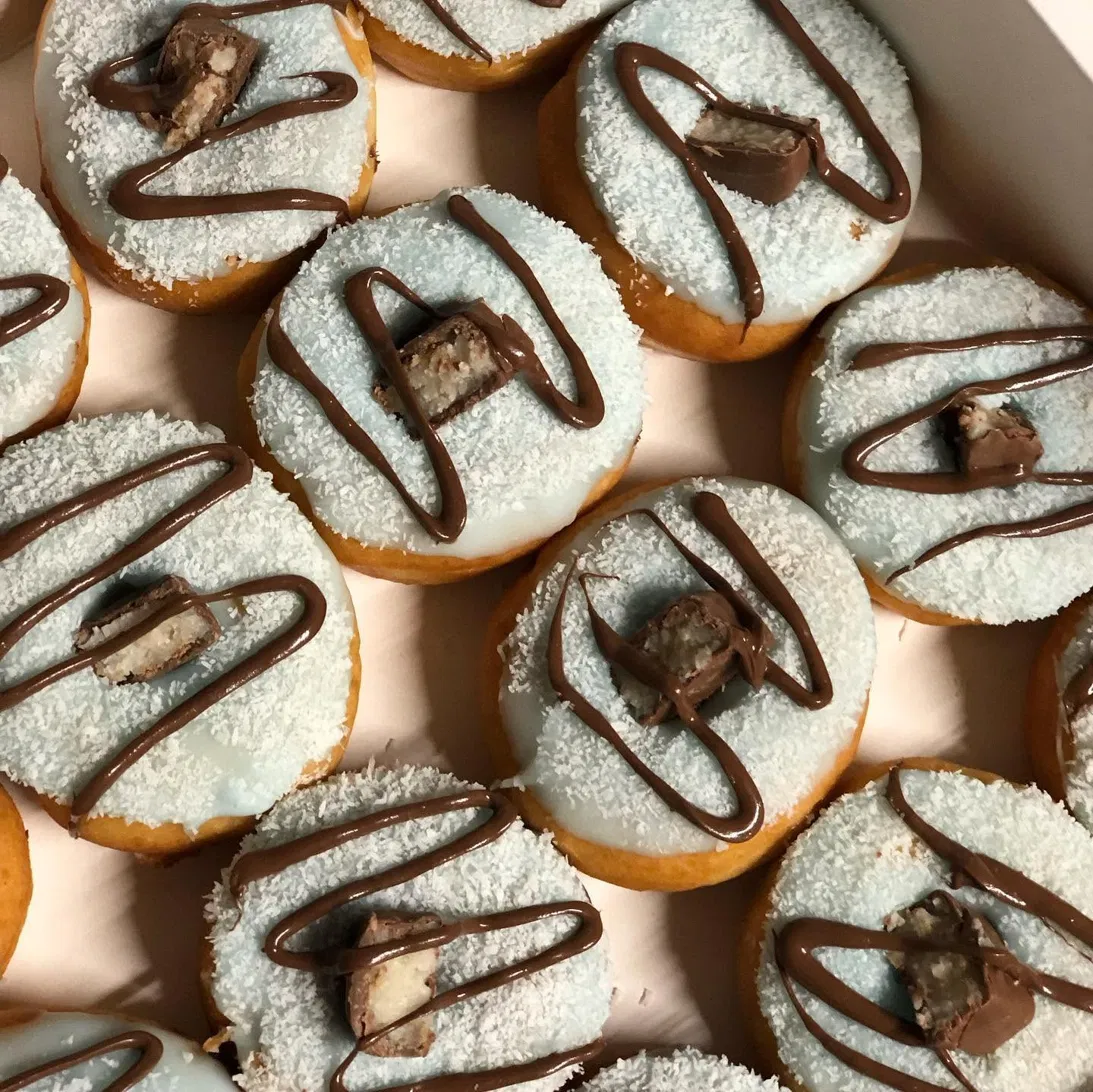 Donuts au glaçage coco bleu lagon, coco râpée et filet de chocolat au lait